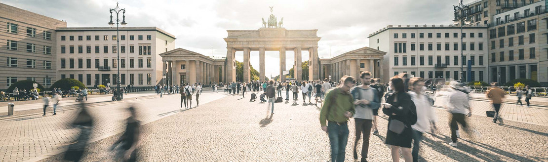 Menschen laufen auf dem Pariser Platz vor dem Brandenburger Tor in Berlin