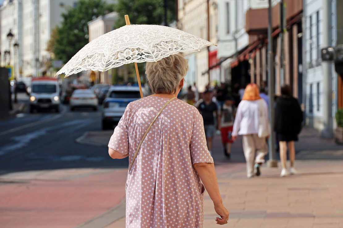 Ältere Dame mit Sonnenschirm