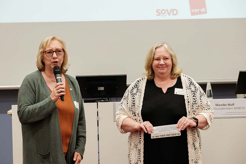 Zwei Frauen stehen vor einem Pult.