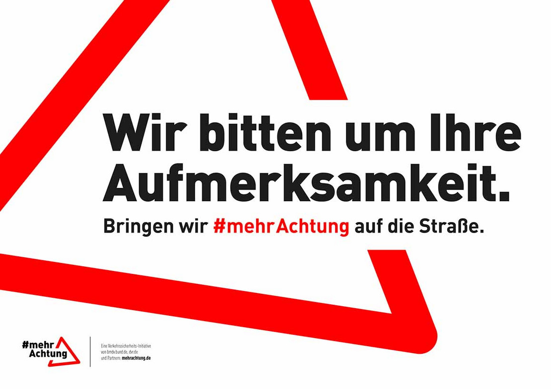 Texttafel mit der Aufschrift "Wir bitten um Ihre Aufmerksamkeit. Bringen wir #mehrAchtung auf die Straße."