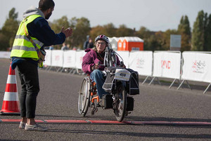 Eine Frau im handbike fährt über die Ziellinie. 