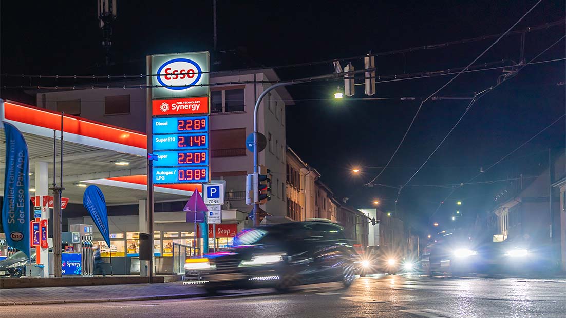 Ein Foto fährt im Dunkeln an einer Tankstelle vorbei. Die Preise liegen bei deutlich mehr als zwei Euro pro Liter.